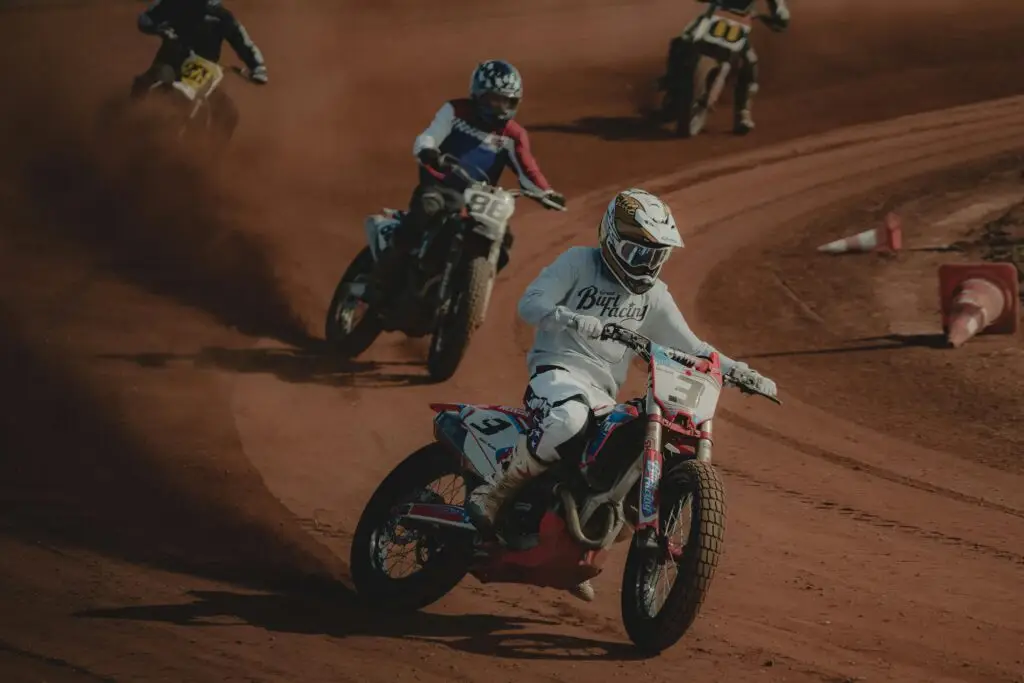 Motorcyclists racing on a dirt track, showcasing speed and agility in an offroad environment.